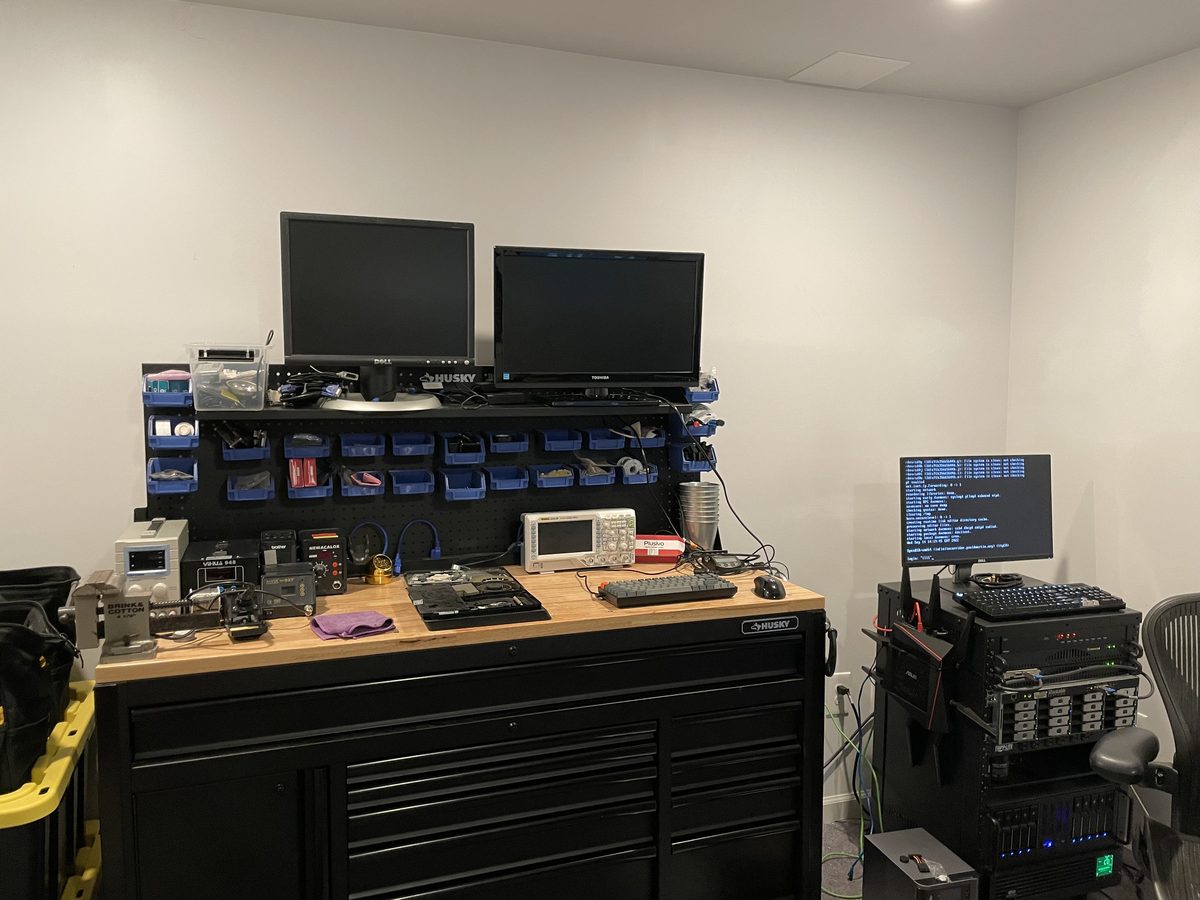 Electronics workbench with oscilloscope, soldering and rework stations, and diagnostic equipment